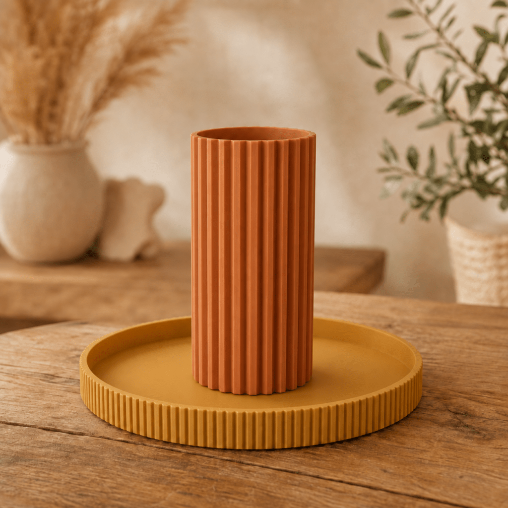3D-gedruckte Vase in Terracotta neben gelber Schale